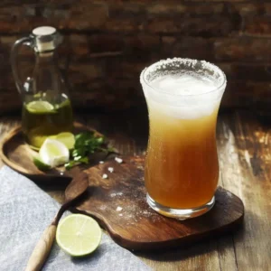 Classic Michelada Recipe: Uncle Frank’s Bold, Backyard Favorite 4 A Michelada served in a tall, salt-rimmed glass with fresh lime and herbs on a rustic wooden board.