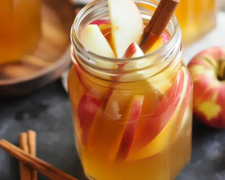 Delicious Fireball apple cider sangria served with fresh apples and cinnamon sticks.