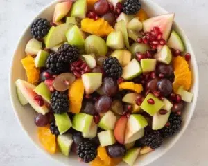 Healthy fall fruit salad with apples, grapes, and orange juice dressing.