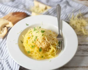 Delicious Garlic Parmesan Spaghetti Squash served with fresh herbs and cheese.