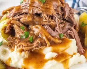 Delicious Mississippi Pot Roast served with gravy and pepperoncini peppers.