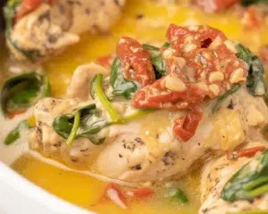 Slow Cooker Tuscan Chicken with sun-dried tomatoes and creamy Parmesan sauce.