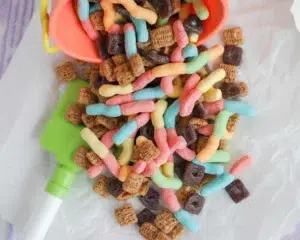 Delicious gummy worm trail mix with Chex, pretzels, and colorful gummies.