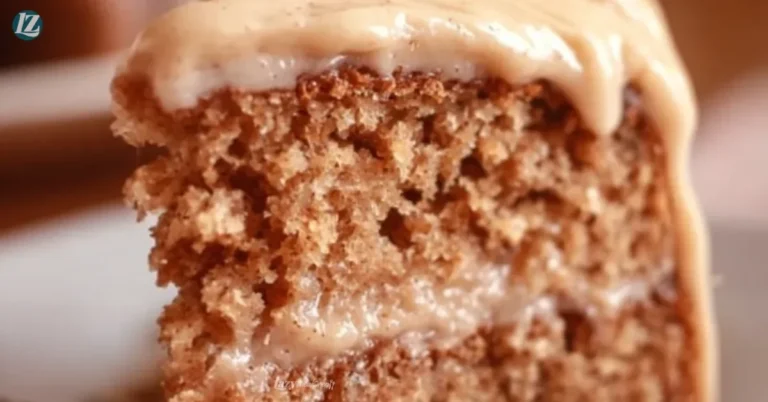 Delicious applesauce cake topped with cinnamon cream cheese frosting on a plate