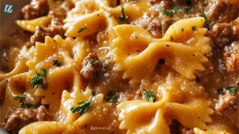 Creamy beef and bowtie pasta dish garnished with herbs