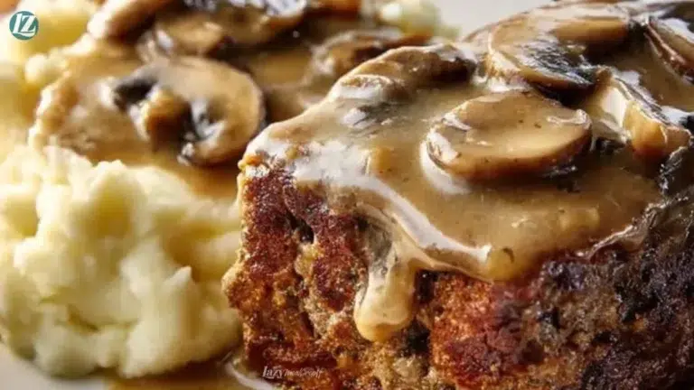 Delicious meatloaf topped with flavorful mushroom gravy served on a plate.