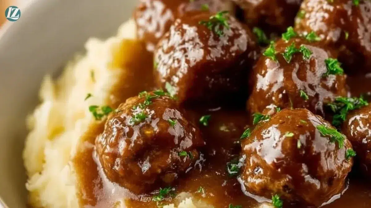 Slow cooker Salisbury steak meatballs served with gravy over mashed potatoes.