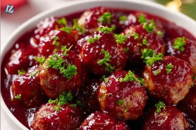 Delicious Christmas Cranberry Meatballs served on a platter, garnished with herbs.