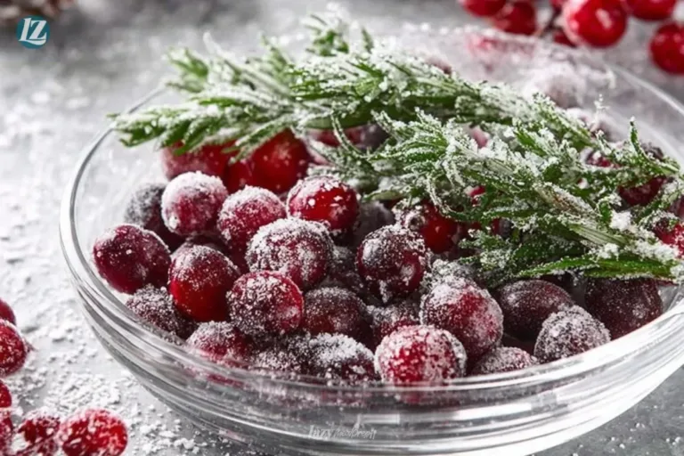 A bowl of sugared cranberries garnished with fresh rosemary sprigs.