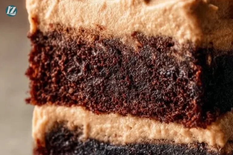Frosted coffee brownies topped with creamy frosting on a white plate.