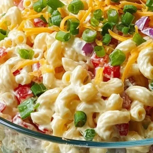 Guy Fieri's vibrant and flavorful macaroni salad garnished with fresh vegetables.