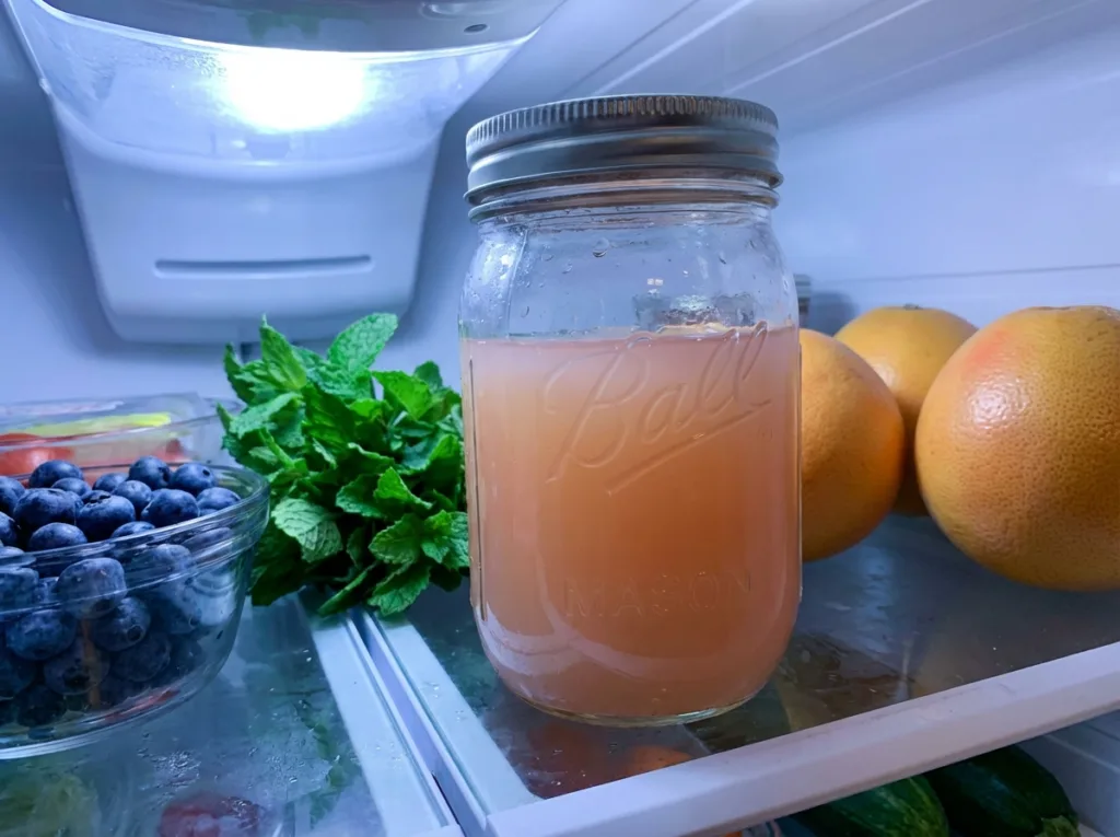glass mason jar of fresh squeezed grapefruit juice stored in refrigerator for weekly batch prep