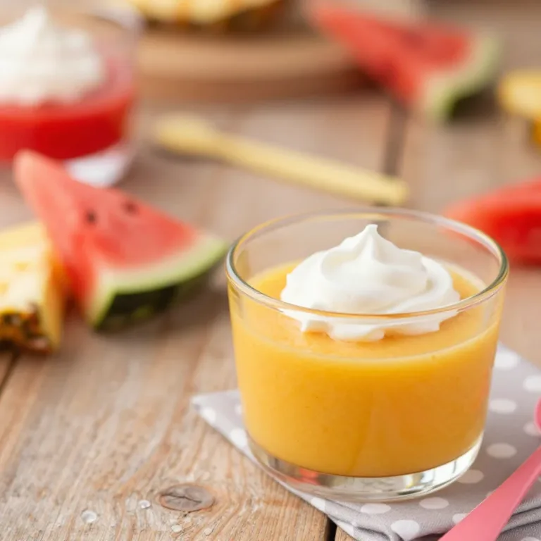 A colorful healthier gelatin dessert topped with fresh fruits in a bowl.
